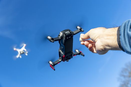 A group of drones fly through the air against a blue sky