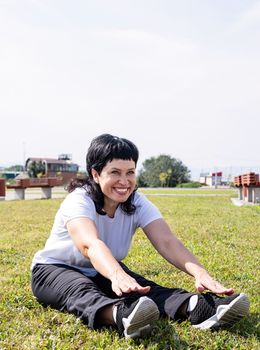 Sport and fitness. Senior sport. Active seniors. Smiling senior woman warming up stretching outdoors in the park