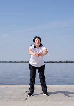 Sport and fitness. Senior sport. Active seniors. Active and happy senior woman exercising near the riverside