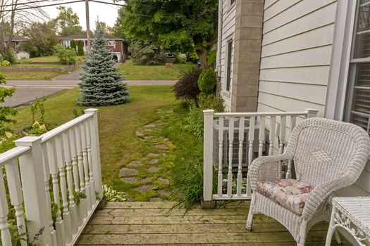 A path of stones, wet after the rain, overgrown with grass and leading along the house to the veranda