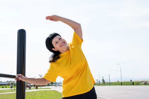 Sport and fitness. Senior sport. Active seniors. Senior woman doing stretching stretching outdoors on the sports ground