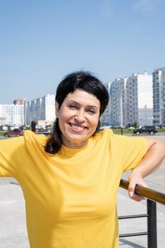 Sport and fitness. Senior sport. Active seniors. Smiling senior woman having rest after workout outdoors on the sports ground bars