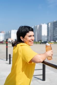 Sport and fitness. Senior sport. Active seniors. Smiling senior woman having rest after workout outdoors on the sports ground bars