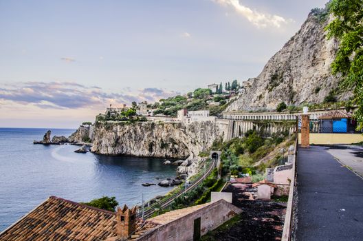 SICILIAN COAST WITH CLIMBING MOUNTAINS AND CONSTRUCTIONS IN THE NEARBY OF THE CITY OF TAORMINA