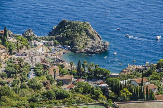 Bay with sandy beach and pier on the mediterranean at the height of the city of taormina sicily italy