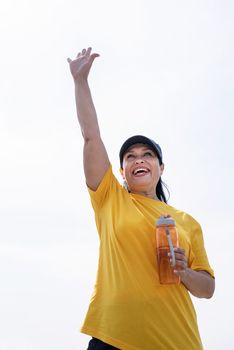 Sport and fitness. Senior sport. Active seniors. Excited senior woman saying hello drinking water after workout outdoors on the sports ground