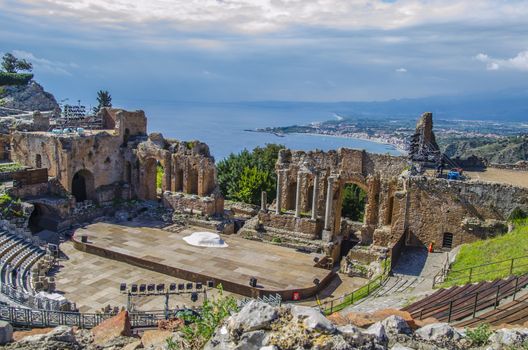 Close-up of the remains of the ancient theater of taormina and panoramic of the coast as background sicily