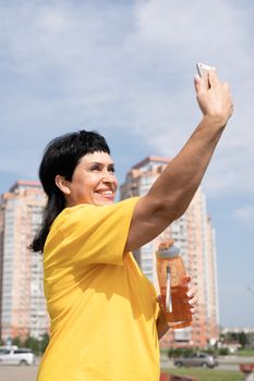 Sport and fitness. Senior sport. Active seniors. Smiling senior sportswoman doing selfie outdoors in the park