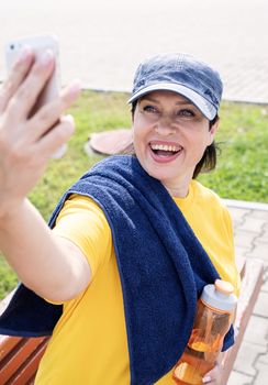 Sport and fitness. Senior sport. Active seniors. Smiling senior sportswoman doing selfie outdoors in the park