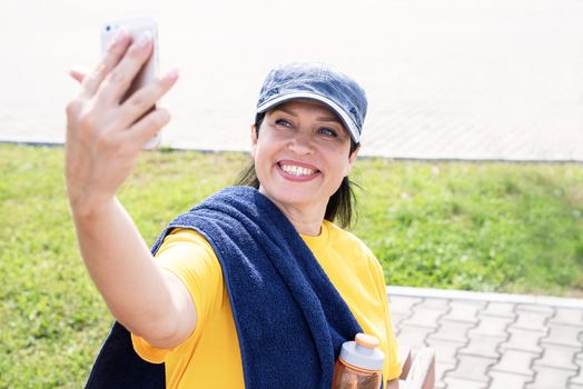 Sport and fitness. Senior sport. Active seniors. Smiling senior sportswoman doing selfie outdoors in the park