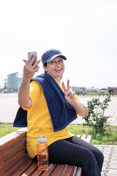 Sport and fitness. Senior sport. Active seniors. Smiling senior sportswoman doing selfie outdoors in the park