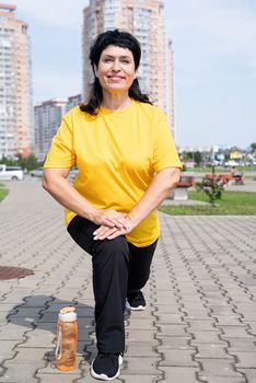 Sport and fitness. Senior sport. Active seniors. Smiling senior woman stretching outdoors in the park