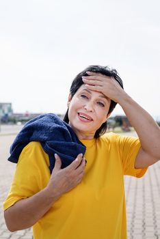 Sport and fitness. Senior sport. Active seniors. senior woman wiping out sweat after hard workout outdoors in the park