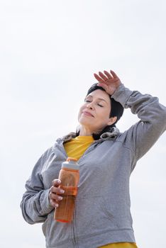 Sport and fitness. Senior sport. Active seniors. senior woman wiping out sweat after hard workout outdoors in the park