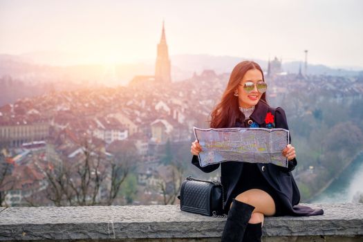 Young female tourist with map looking for a way to Beautiful view point near old town in Bern, Switzerland
