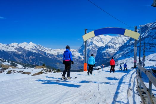 Skier skiing downhill in high mountains Kleine Scheidegg station at Switzerland