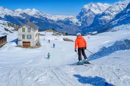 Skier skiing downhill in high mountains Kleine Scheidegg station at Switzerland