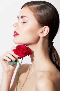 Woman with red flower Eyes closed naked shoulders side view charm cropped view