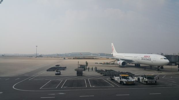 Beijing Airport, china- April 2019: Passenger plane standing in airport on the concrete paved runway terminal for loading, boarding and maintenance before take off for predestined flights.
