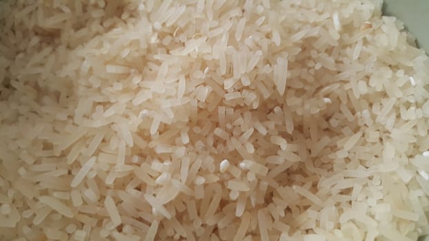 Top closeup view of heap of rice. Rice is the most consumed food ingredient in the world