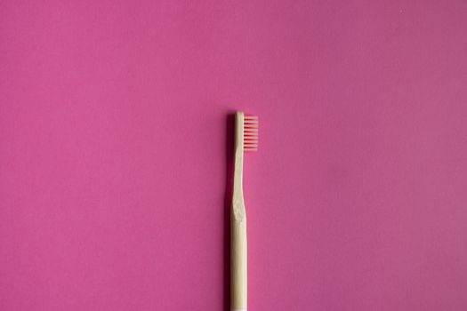 Eco-friendly bamboo toothbrush on a pink background. Zero-waste. Biodegradable toothbrush