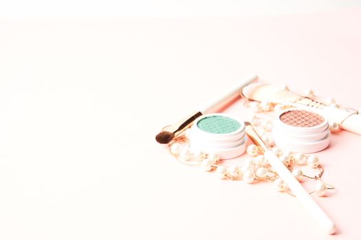 Makeup brushes, eyeshadows, decorative cosmetics and beads on a light background. High quality photo