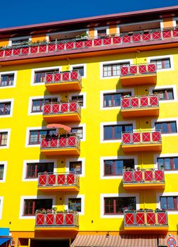 A yellow apartment house with red balconies