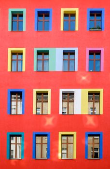 A red building facade with colourful windows