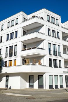 A modern white townhouse in front of a blue sky