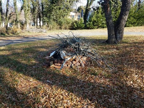 sticks or branches and trash in pile on red bricks with leaves