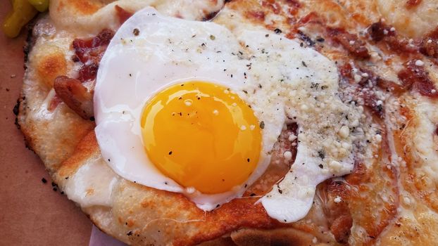 egg and bacon and cheese breakfast pizza in cardboard box