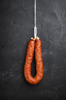 Spanish pork chorizo sausages on black textured background.