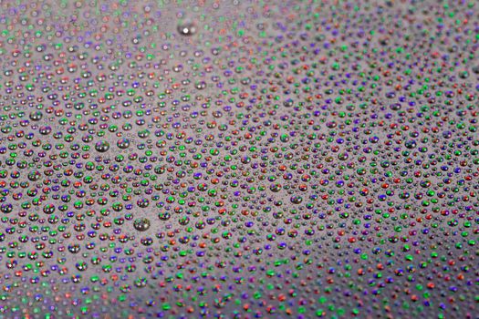 many small water drops on the surface of cellphone hydriphobic coated glass screen, close-up with selective focus and visible subpixel rgb triads