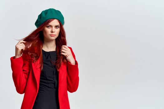 Woman in red coat and in green hat on isolated background cropped model with Copy Space emotions. High quality photo