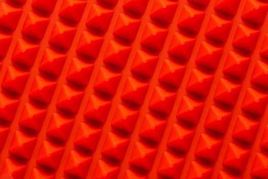 abstract red silicone pyramids array close-up background.