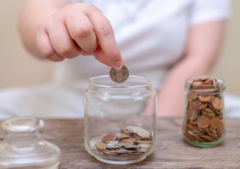 Save money and account banking for finance concept, Hand with coin bottle blurred background