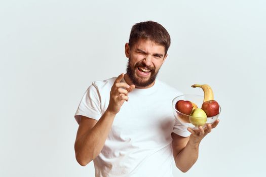 man with fresh fruit in a glass cup gesturing with hands vitamins health energy model bushy beard mustache. High quality photo