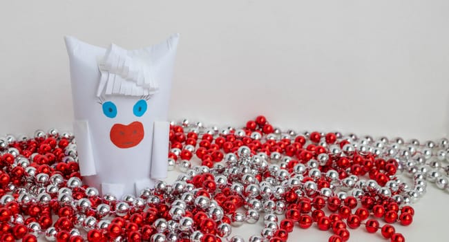 White paper bull as a symbol of New year and Christmas 2021 with red and silver beads on a white background