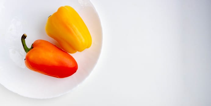 Fresh vegetables two orange peppers isolated on a white background.Space for your text