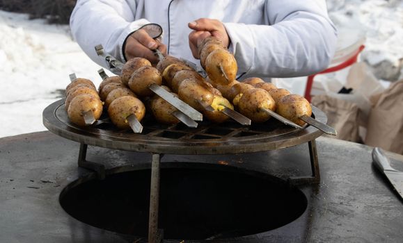 Grilled fresh potato tubers strung on skewers