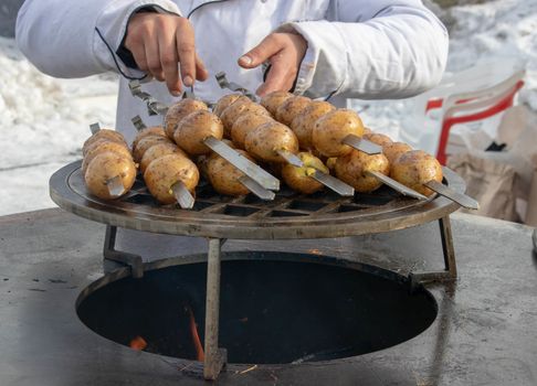 Grilled fresh potato tubers strung on skewers