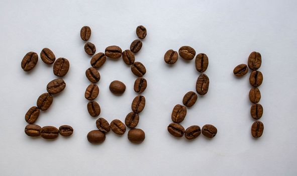 Image of the new year 2021 numbers from coffee beans on a white background