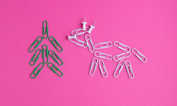 Year of the bull 2021.Colorful paper clips isolated on a pink background. Office supplies. Stapling documents and paper with paper clips.