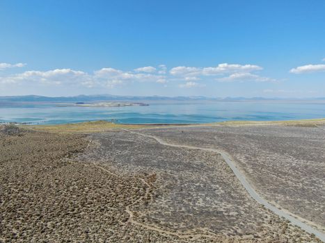 Aerial view of dusty dry desert land with Mono Lake on the background, Mono County, California, USA