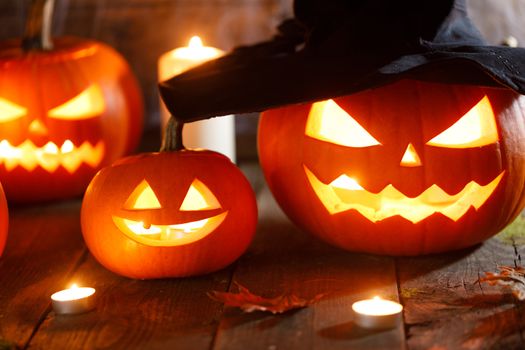 Jack O Lantern Halloween pumpkin with witches hat , spiders on web and burning candles