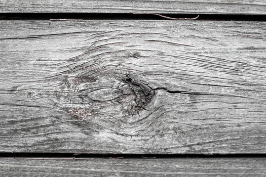 Wooden background made of old boards. The texture of an old rustic wooden fence made of flat processed boards. Wooden fence made of old boards with the inclusion of Knots. Background design