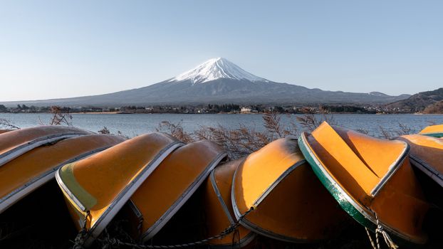 View of Mt. Fuji or Fuji-san with yellow boat and clear sky at lake kawaguchiko, Japan.