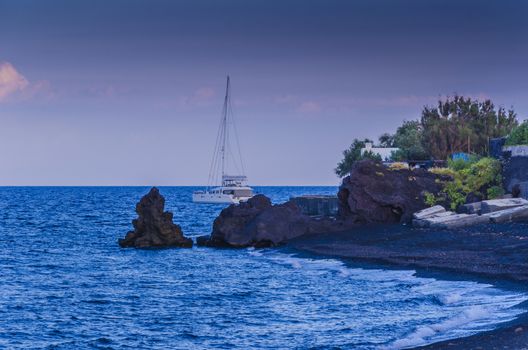 Bay beach volcanic sand volcanic rocks and boat on stromboli island italy