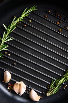 barbecue grill frying pan or skillet close up black with herbs for cooking top view concept for text or objects vertical.