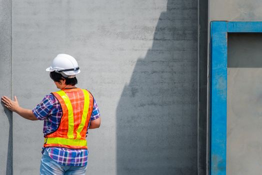 Asian woman civil construction engineer worker or architect with helmet and safety vest happy working at a building or construction site